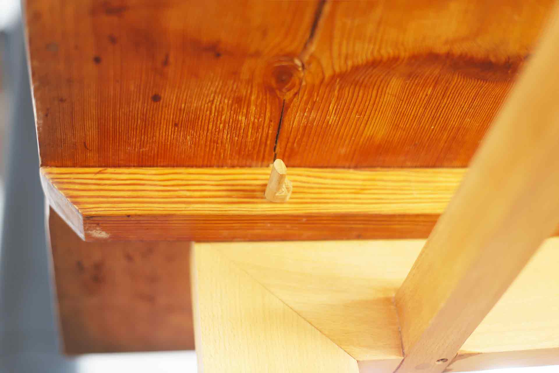 Handgjord träplugg håller bordsskivan av gamla golvplank till ett underrede i bok. Formgivare är arkitekt Anders Frelin.
