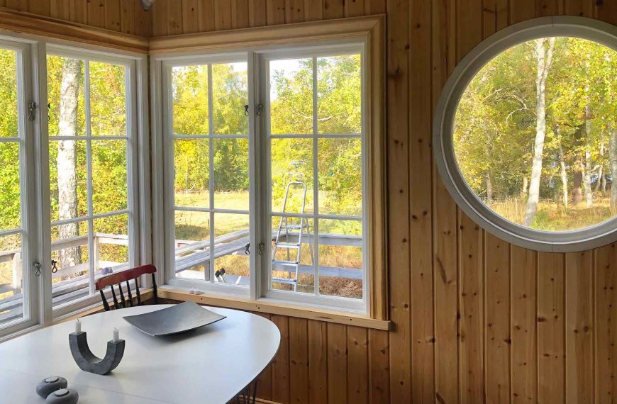 Kök får handtillverkat stort runt fönster. Utanför syns björkskogen och skärgårdshavet. Arkitekt är Anders Frelin.
